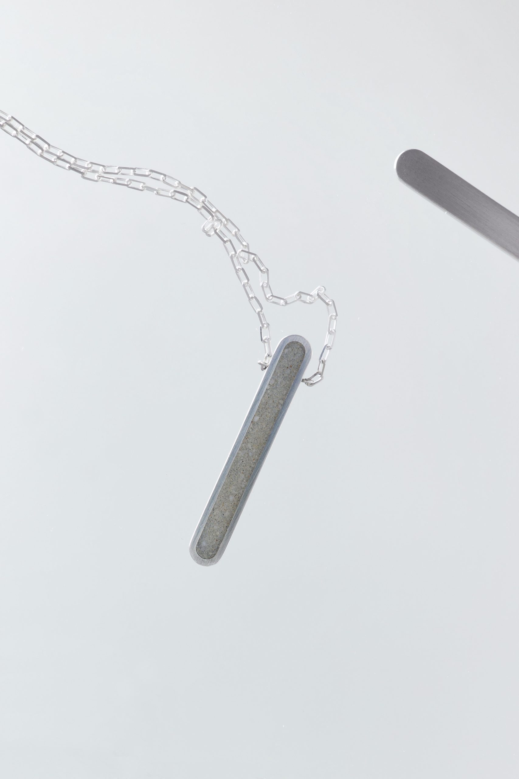 Arcil necklace – handcrafted concrete and silver minimalist architectural jewelry.