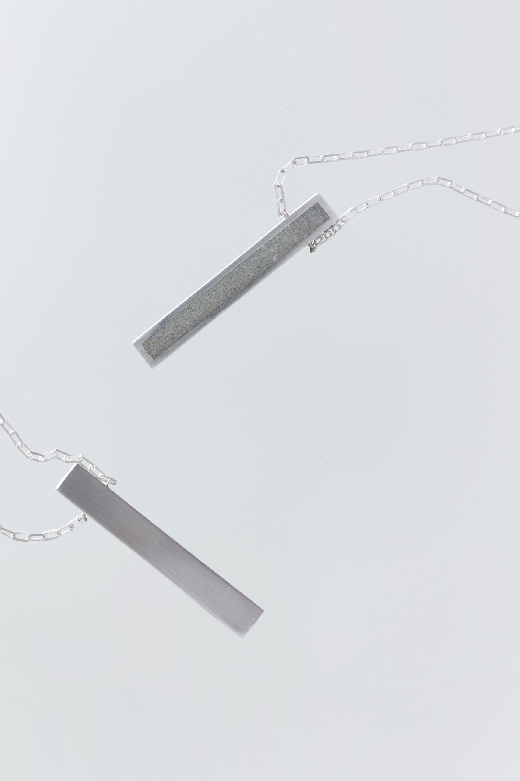 Lintour necklace – handcrafted concrete and silver minimalist architectural jewelry.