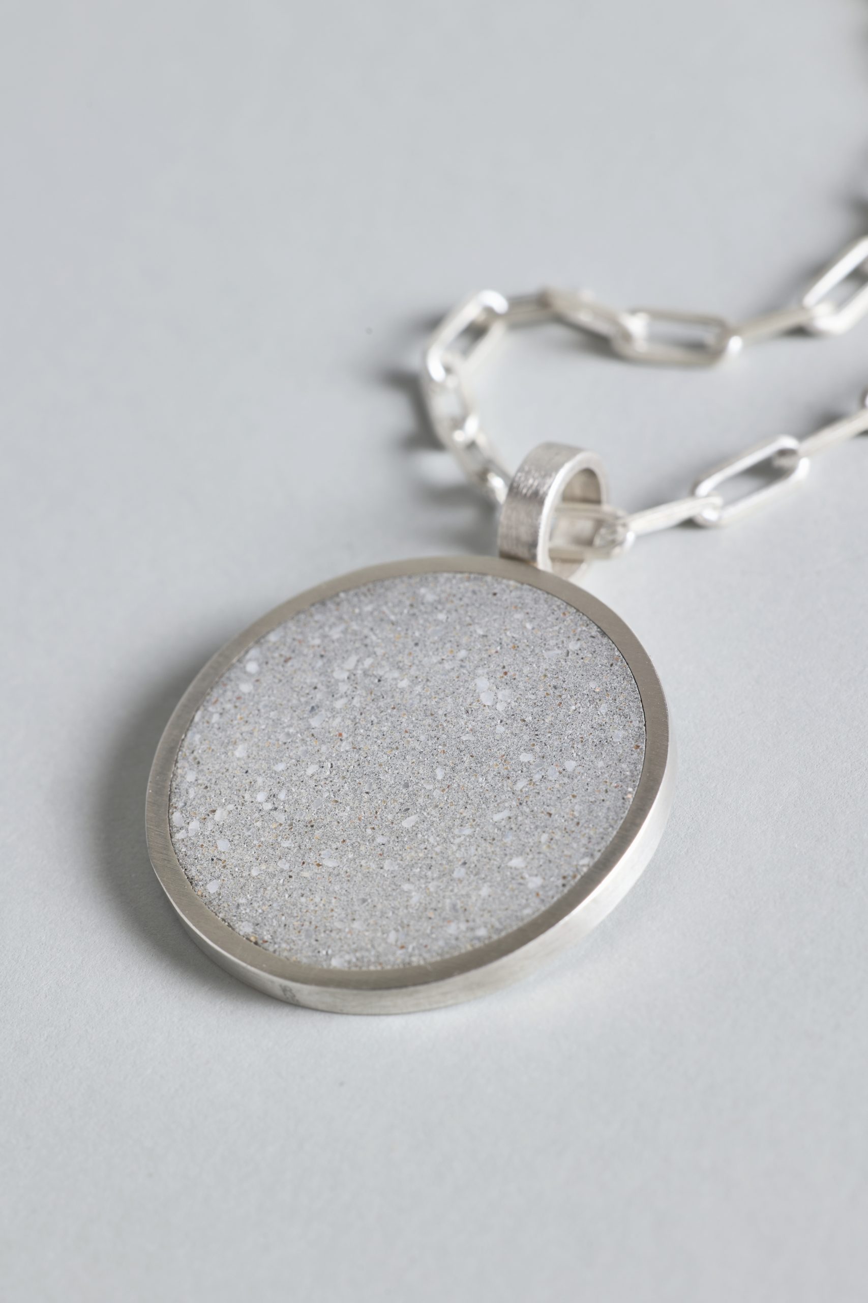 Revorta necklace – handcrafted concrete and silver minimalist architectural jewelry.