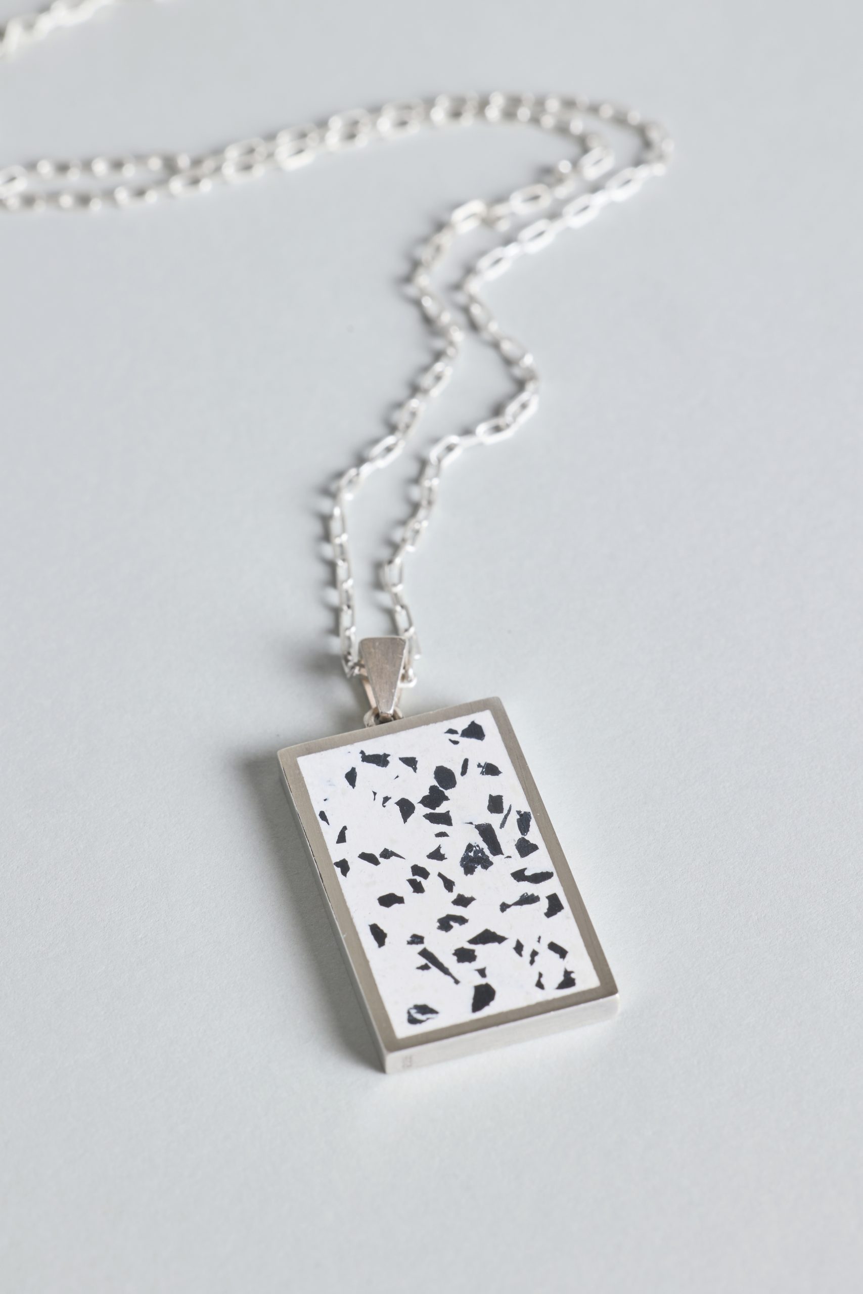 Solmant necklace – handcrafted concrete and silver minimalist architectural jewelry.