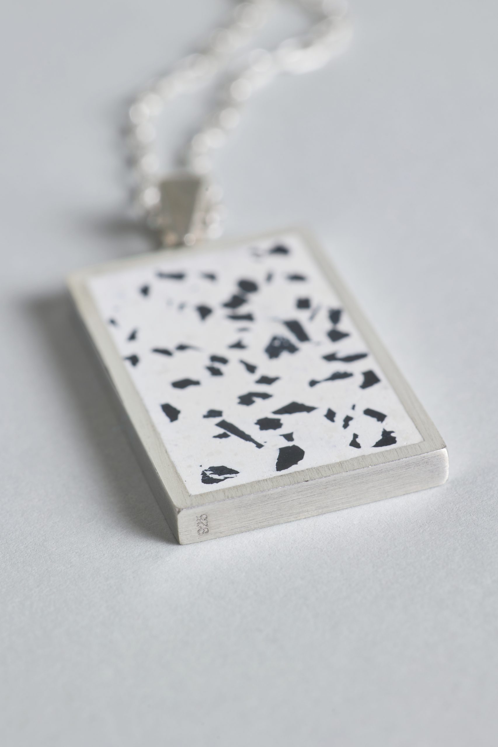 Solmant necklace – handcrafted concrete and silver minimalist architectural jewelry.