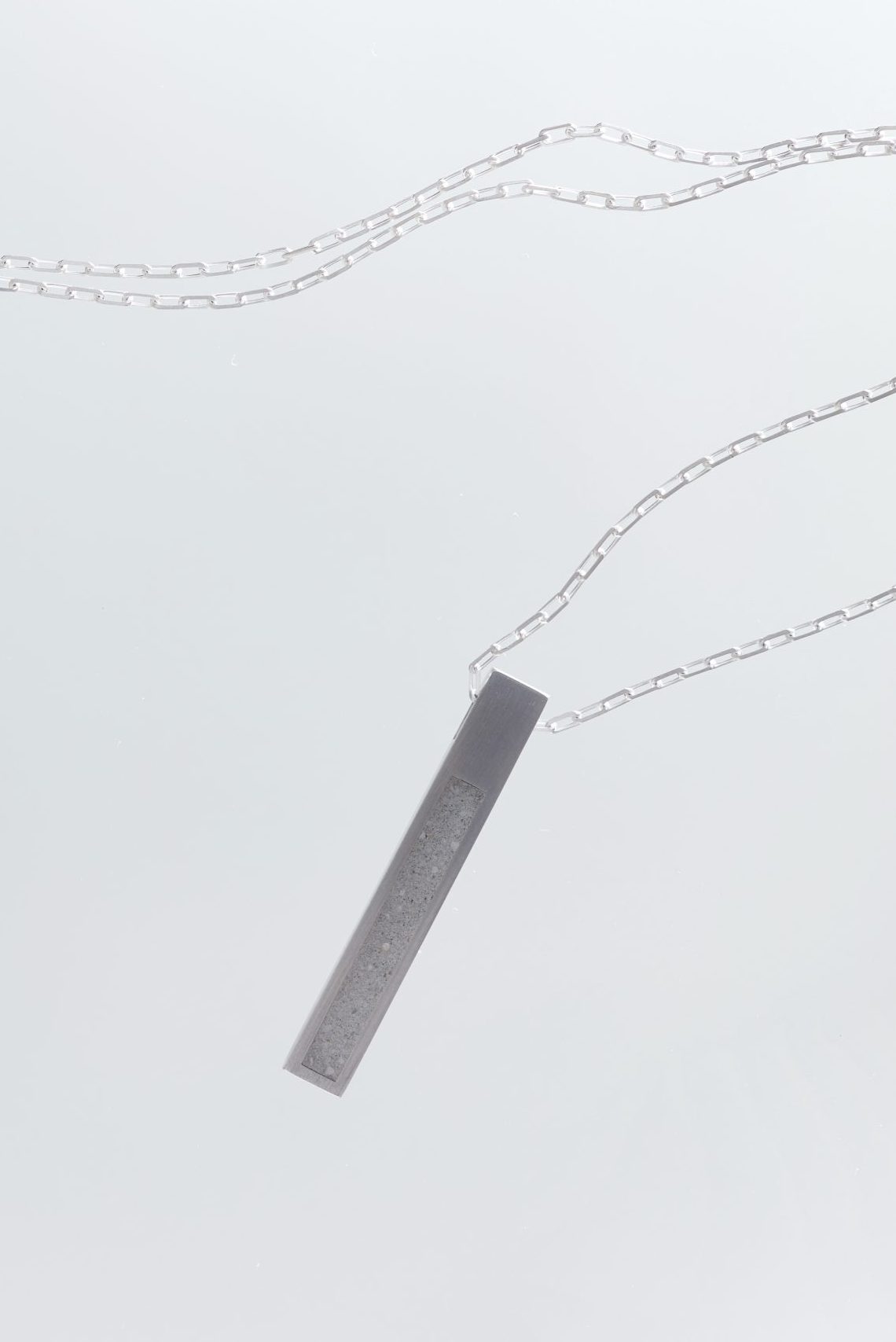 Strund necklace – handcrafted concrete and silver minimalist architectural jewelry.